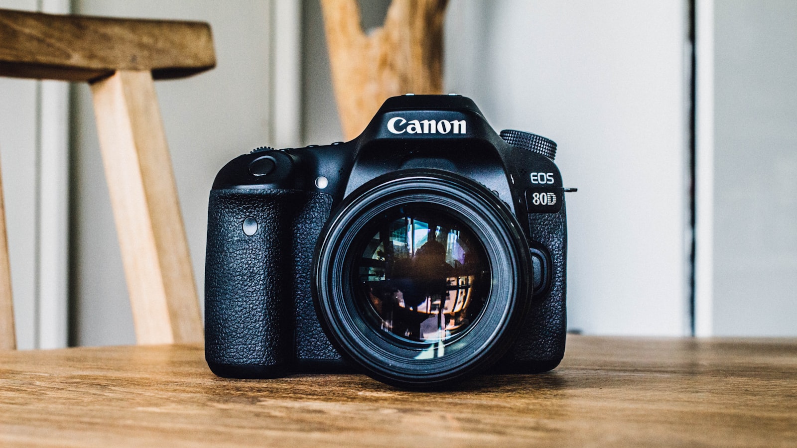 A camera lens resting on a flat surface with the front element facing up.