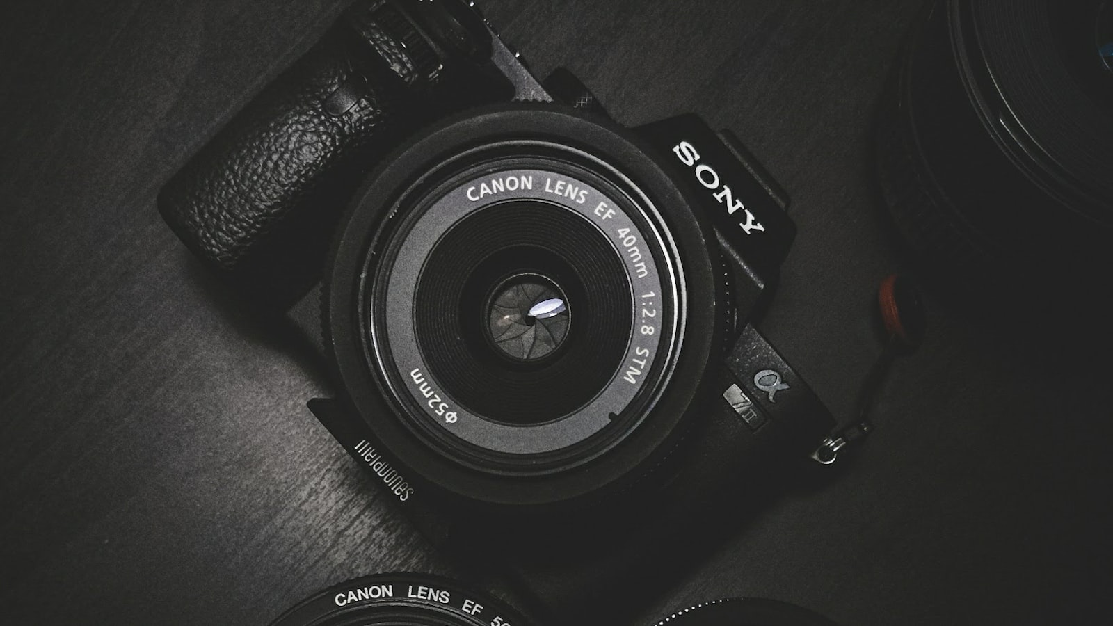 A camera and lens arranged on a desk.