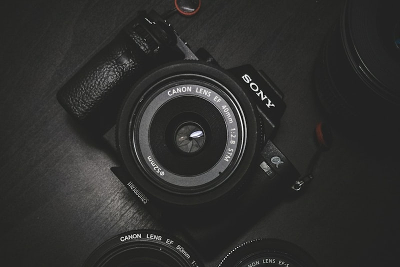 A camera and lens arranged on a desk.