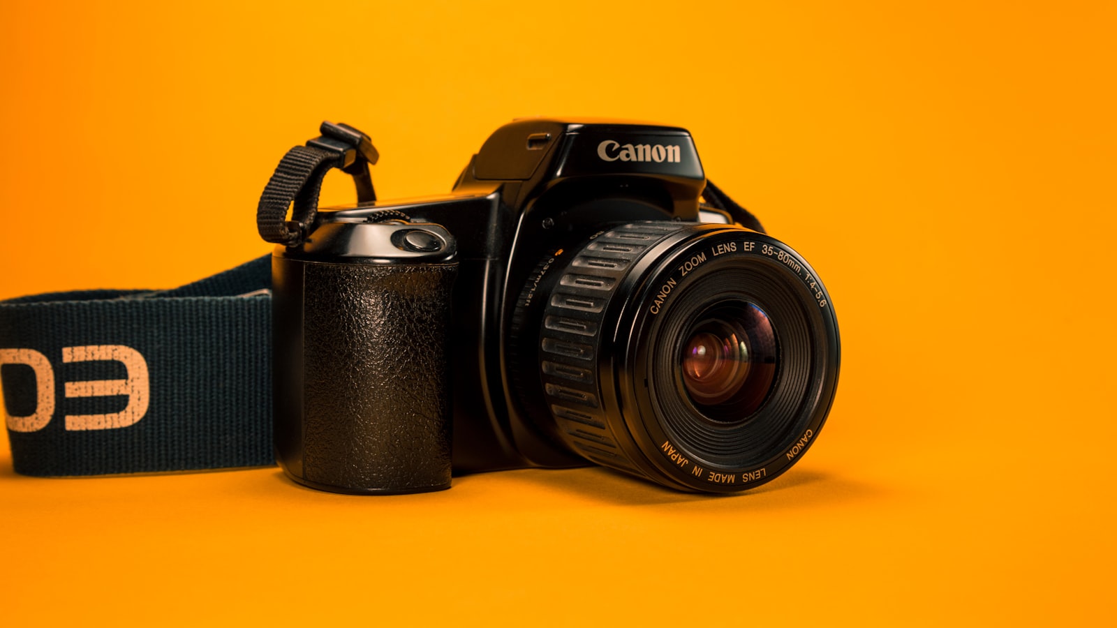 A camera body photographed in low, moody light on a dark surface.
