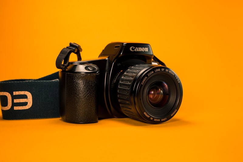 A camera body photographed in low, moody light on a dark surface.