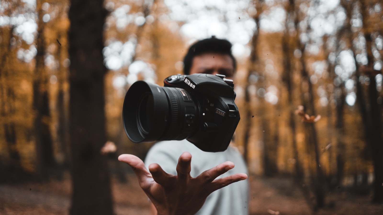 A camera lens being focused, with the focus ring in the foreground.